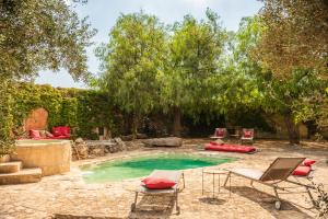 曼杜里亚Masseria Li Reni的后院设有带椅子和桌子的游泳池