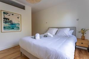 拉特斯特德布赫Pyla Plage - appartement vue mer - Perle(o)的卧室配有白色大床和白色枕头