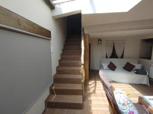 Santa Colomba de la VegaCASA RURAL VEGASAN的通往卧室的楼梯,卧室配有一张床
