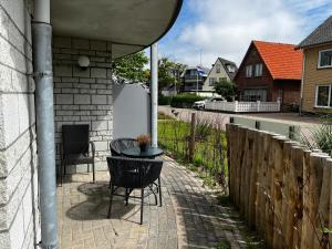 德科赫Texelheerlijk 10的一个带桌椅和围栏的庭院