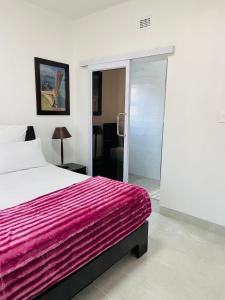 马盖特Unit 3, Marine Terrace的一间卧室配有一张带粉色毯子的床