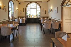 格斯塔特荷斯坦霍夫餐厅公寓的餐厅设有桌椅和窗户。