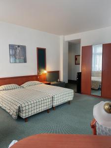 布鲁塞尔勒多姆酒店的酒店客房设有两张床和一张桌子。