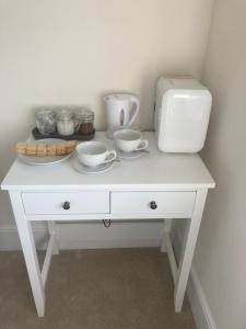 PortskewettMill Meadows的一张带碗和烤面包机的白色桌子