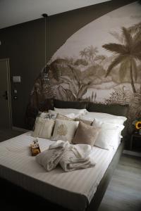 萨莱诺B&B Les Lumières的卧室配有一张大床,墙上挂有绘画作品