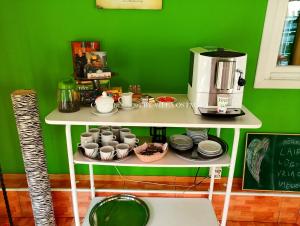 文茨皮尔斯Villa Ostmala的绿色的墙,带杯子的架子和咖啡壶