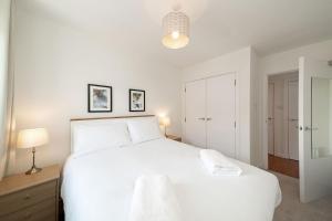 卡诺斯蒂At The Links的白色的卧室配有一张白色的大床和一盏灯