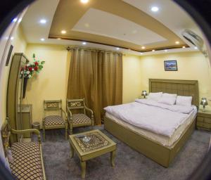 锡卡都Ringachan Guest House & Restaurant的一间卧室配有一张床、两把椅子和一张桌子