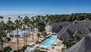 吉汶瓦Diamonds Mapenzi Beach的享有度假村的空中景致,设有游泳池和棕榈树