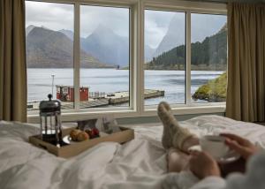 SæbøSagafjord Hotel - by Classic Norway Hotels的躺在床上看窗外的人