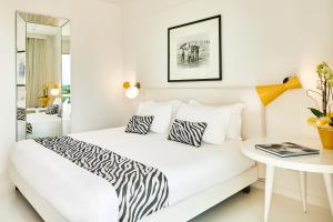 马里纳-迪-皮特拉桑塔蒙迪艾尔度假温泉酒店的白色卧室配有带斑马枕头的床