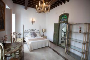 库埃瓦斯德拉尔曼索拉El Palacete de Cuevas的一间卧室配有一张床和一个吊灯