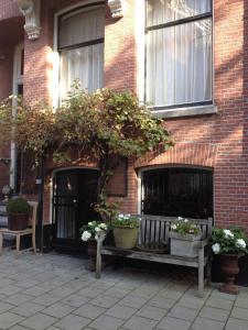 阿姆斯特丹十九旅馆的砖砌的建筑,有两长椅和盆栽植物