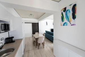 马马亚White Tower Mamaia Apartament Privat 503的厨房以及带水槽和桌子的客厅。