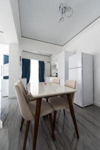 马马亚White Tower Mamaia Apartament Privat 503的白色的用餐室配有桌椅