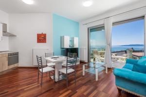 奥帕提亚Stella Premium Apartment Opatija的客厅配有蓝色的沙发和桌子