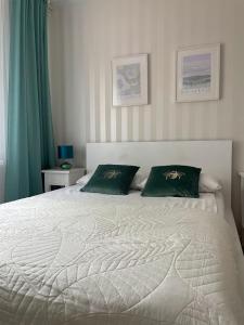 索波特Pokój dla dwojga w zacisznej części Sopotu z łazienką wspólną dla dwóch pokoi的卧室配有白色床和2个绿色枕头