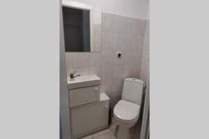 索波特Pokój dla dwojga w zacisznej części Sopotu z łazienką wspólną dla dwóch pokoi的一间带卫生间、水槽和镜子的浴室