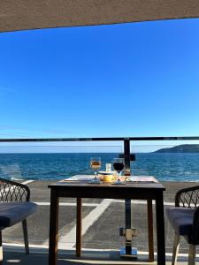 卡桑德Ocean View的一张桌子,上面有两杯葡萄酒在沙滩上