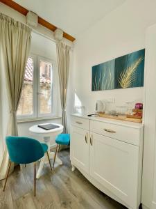 杜布罗夫尼克Ida Old Town Rooms的白色的厨房配有蓝色椅子和水槽