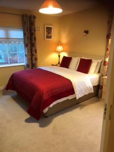 Dún LuáinBlackrath Farmhouse的一间卧室配有一张带红色毯子的大床