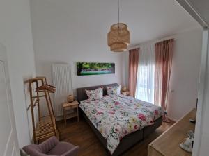 尼德根Ferienwohnung Eifeloase的卧室配有床、椅子和窗户。