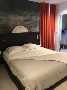 皮耶尔佩尔塞埃Logis Hôtel Altitude et Spa Pierre-Percée的一间卧室配有一张带红色窗帘的大床