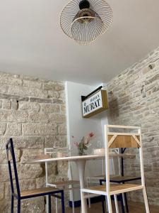 努瓦埃尔Logement entier - L'Appart des anges 1的一间设有桌椅和砖墙的用餐室