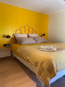 努瓦埃尔Logement entier Noyers - L'Appart des Anges 2的一间卧室设有一张黄色墙壁的大床