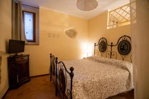 斯佩洛Nel vicolo dei Baci - Casa vacanze al Bacio的一间卧室配有一张床、一台电视和一个窗口