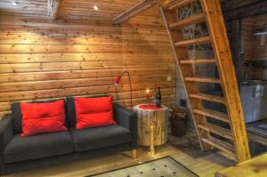 Karlsten拉普兰/瑞典溪流小屋的客厅配有红色枕头的沙发