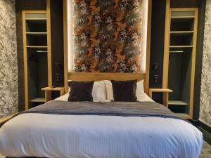 TreignacHôtel La Brasserie的一间卧室配有一张大床和大床头板