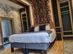 TreignacHôtel La Brasserie的一间卧室配有一张特大号床和花卉壁纸