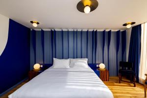 伦敦Limehouse Library Hotel的一间卧室配有一张带蓝色墙壁的大床