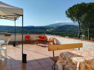 AlannoAgriturismo Le Terre d'Abruzzo Country House的庭院配有桌椅和遮阳伞。