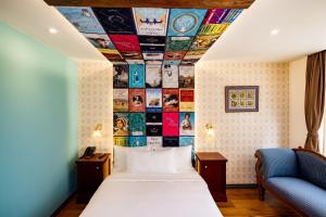 伦敦Limehouse Library Hotel的一间房间,配有一张床和一张专辑覆盖的墙壁