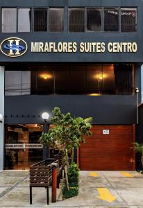 利马Miraflores Suites Centro的坐在大楼前的长凳
