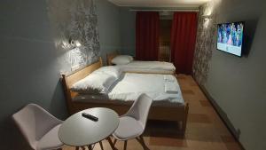 厄尔科Villa Eden & Restaurant的小房间设有一张床、一张桌子和椅子