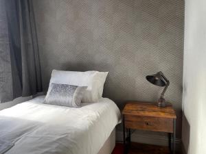 巴罗弗内斯德比酒店的一间卧室配有一张床和一张带台灯的桌子