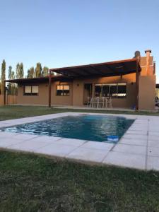 查克拉斯德科里亚Las Casitas y Los Duplex de Chacras de Coria的房屋前有游泳池的房子