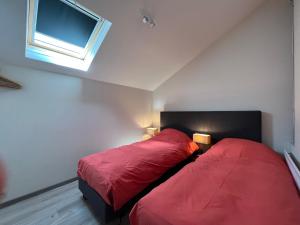 Bossut-Gottechain萨库拉公寓的一间卧室设有两张带红色床单的床和窗户。