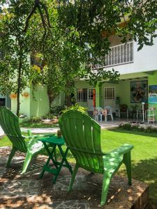 圣安德烈斯波萨达纳迪瓦伯纳德广场宾馆的两把绿色椅子和一张桌子位于房子前面