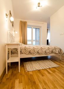 维尔纽斯美梦公寓的一间卧室配有一张带书桌的床和窗户。