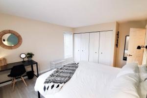 East BurkeBurke Abode - Trailside Condo with King & Full Beds的卧室配有一张白色大床和一张书桌