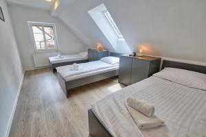 卢斯AUžlak hiša, apartments.的阁楼卧室设有两张床和窗户。