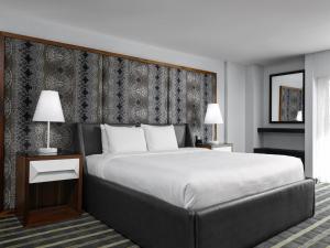 卡尔加里艺术酒店的一间卧室配有一张大床和两盏灯。