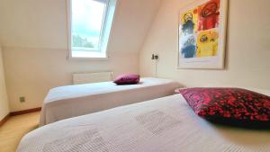 伦讷Bornholm Majalis的一间卧室设有两张床和窗户。