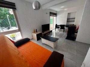 罗列特海岸Apartamentos La Isla的客厅配有橙色沙发和电视