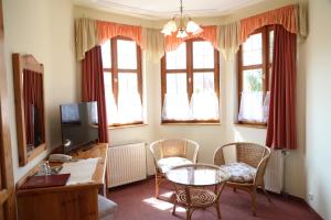 豪伊杜索博斯洛豪伊杜城堡酒店的客厅配有桌椅和窗户。