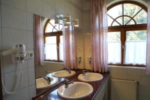 豪伊杜索博斯洛豪伊杜城堡酒店的浴室设有3个水槽和2面镜子